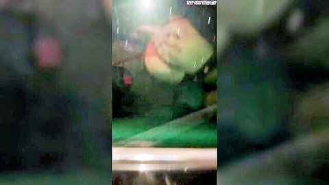 Blurry naughty woman in car window during rainy dogging in parking lot