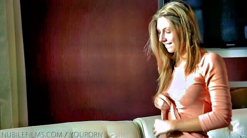 Krystal Boyd in pink sweater, seductive smile on couch