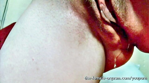 Close-up of wet neck and shoulder during intense female orgasm, standing and dripping