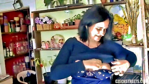 Brunette mature flashing big natural tits pulling open blue sweater smiling indoors