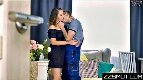 Blonde woman in black dress passionately kisses handyman in overalls