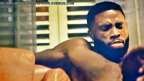 Muscular black man with intense expression in intimate couch scene