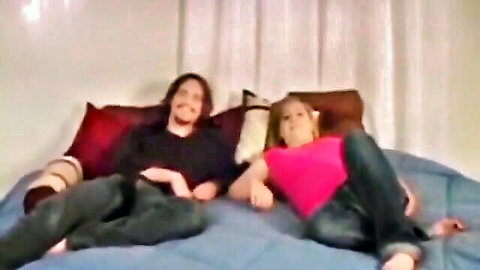 Casual amateur couple lounging on bed in holiday-themed adult video thumbnail