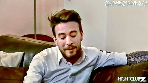 Tattooed handsome man in white shirt lounging seductively for sexy mommy fantasy