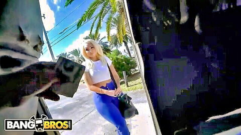 Blonde Alexis Andrews in white crop top and blue leggings outside Bang Bus