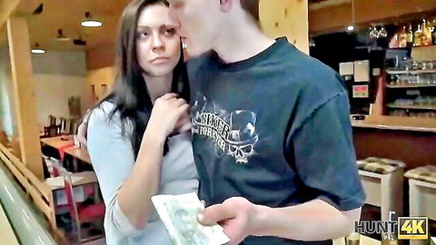 Brunette couple in bar negotiating sex for cash with tense kiss
