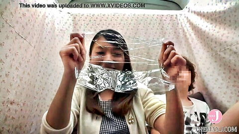 Asian woman in cardigan holding foil sheet, blurred oral scene in tent, JAV intro