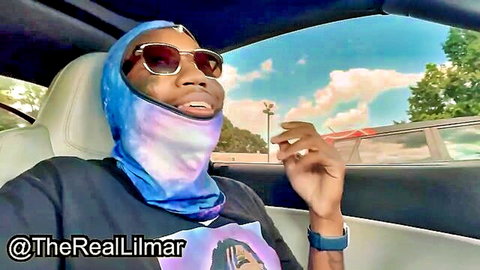 Lilmar in galaxy ski mask smiling in convertible car with Cuban mami