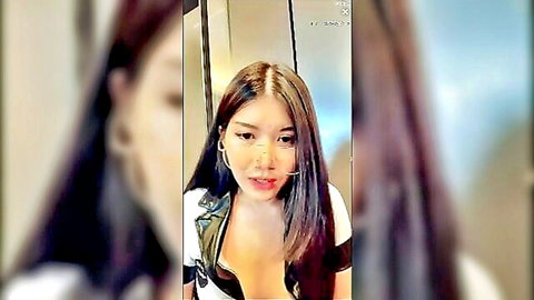 Seductive Asian woman with long dark hair in low-cut top showing cleavage