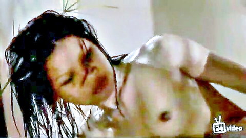 Wet Asian woman nude with intense expression, exposing breasts