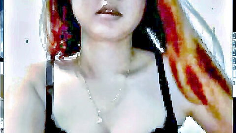Seductive redhead beauty in black top showing off cleavage teasingly