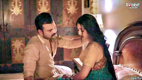 Indian man caresses beautiful desi woman's face intimately on ornate bed in saree