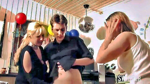 Two busty blondes tease guy lifting open shirt at wild party with balloons and disco balls