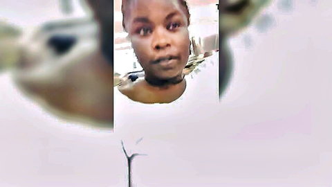 Ebony woman with serious gaze in white tank top, close-up portrait