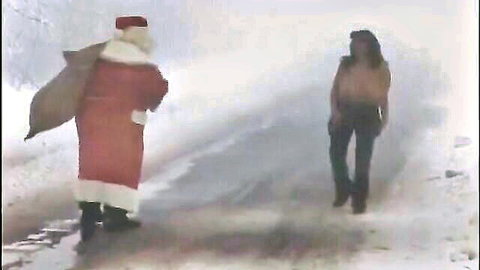 Topless big-titted brunette in public snow nudity with Santa outdoors