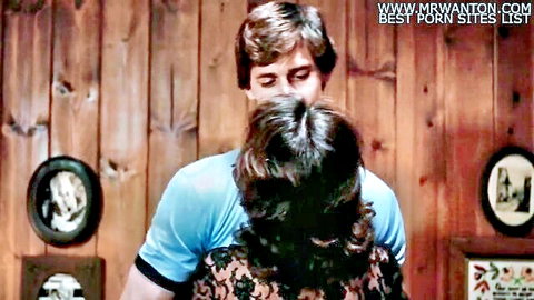 Vintage couple embrace: man hugs brunette in lace top from behind