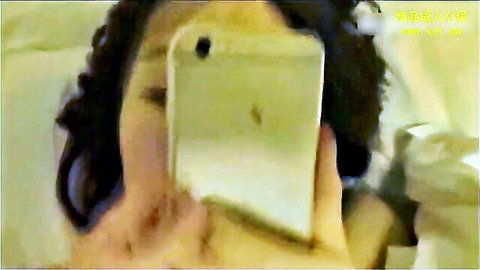 Asian wife taking selfie while on phone during intimate moment