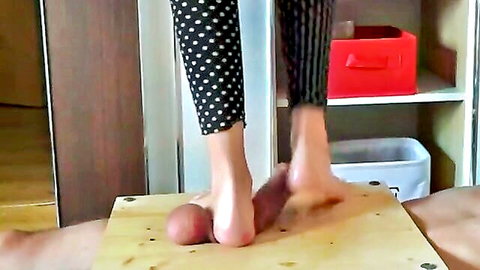 Clothed woman in polka-dot leggings tramples naked man's swollen balls with bare feet