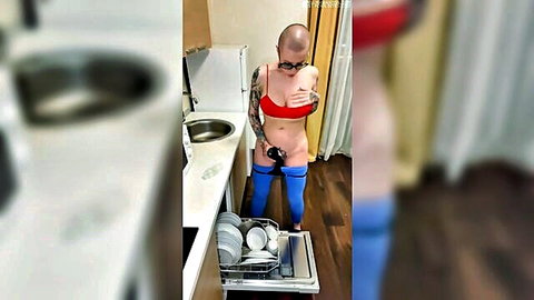 Bald tattooed babe with huge tits pulls down red bra flashing boobs in kitchen by dishwasher