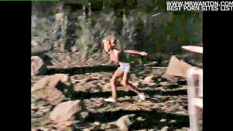 Blonde woman running topless in shorts in Texas Dildo Masquerade horror parody