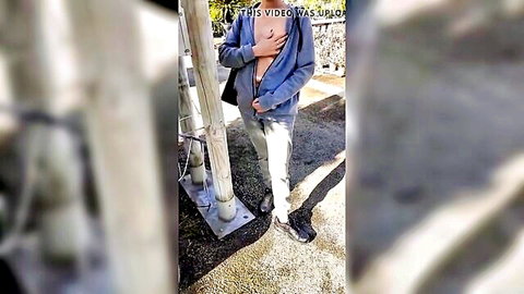 Slim Asian woman flashing breasts in open hoodie at garden center outdoor