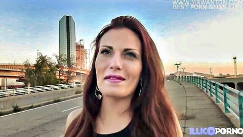 Cyann redhead in black top posing seductively on urban bridge at dusk