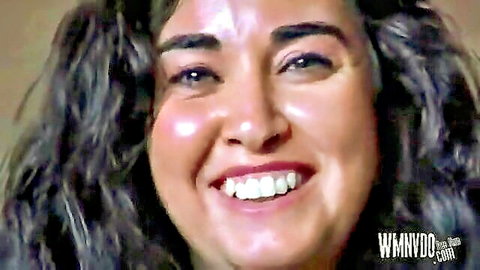 Smiling mature woman with curly gray-streaked hair and glossy lips teases before amateur threesome fuck