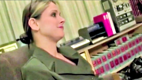 Blonde woman in green suit smiling seductively in vintage studio with synths