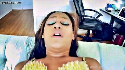 Ecstatic ebony babe with medium tits spilling from yellow top, mouth agape in pleasure on couch