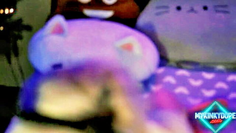 Cute purple and gray cat plush toys glowing in dark room with neon lights