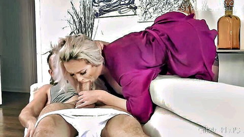 Blonde MILF in open purple robe grips and sucks stepson's throbbing cock on white couch