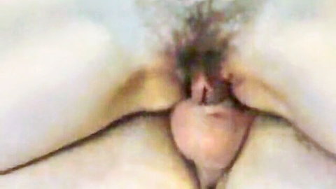 Close-up of hairy pussy with spread pale labia revealing pink inner lips and clit