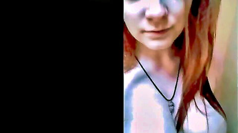 Freckled redhead teen smiling seductively with necklace and bare shoulders