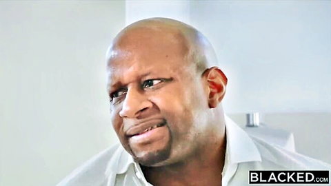 Bald Black man with intense stare wearing white shirt in Blacked.com promo