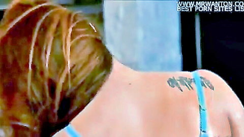 Tanned skinny babe with long hair and back tattoo teases average ass in blue bikini bottoms in kitchen