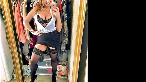 Curvy blonde in black lace bra, stockings and garters posing seductively in mirror selfie
