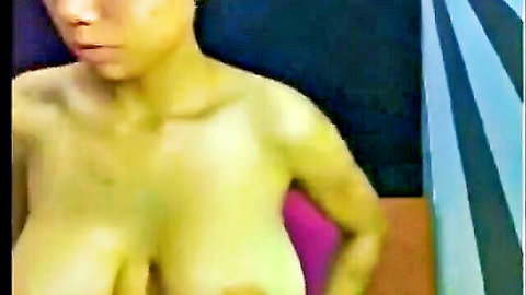 Asian beauty with massive breasts exposing topless in seductive pose