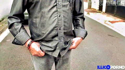 Mature man in gray shirt and pants stands outdoors, hands in pockets - Illico Porno teaser