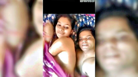 Smiling topless Indian wife baring tits cuddling naked husband in bed homemade amateur