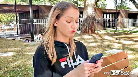 Blonde Brazilian model Larissa Leite in hoodie on phone in park tease