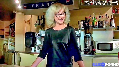 Blonde MILF Isabelle smiles in black top at her bar, naughty anal tease