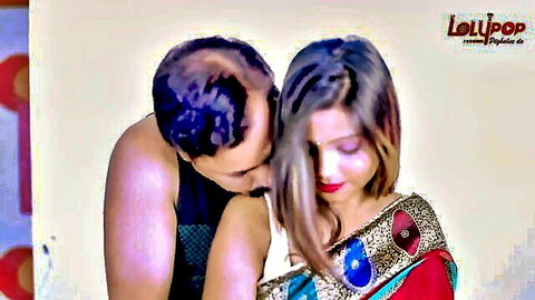 Desi couple in passionate embrace, man kissing woman's neck in colorful saree