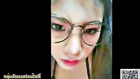 Close-up of sexy Thai woman in round glasses with red lips smirking seductively
