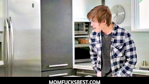 Young stepson in plaid shirt stares at stepmom in kitchen before hot fuck