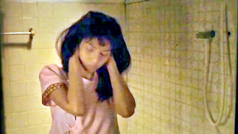 Thai beauty in pink top touching face seductively in bathroom