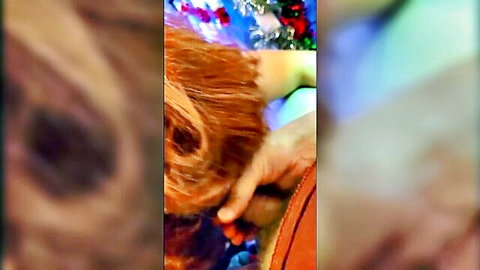 Blurry close-up of redhead Steffi's hair and hand amid Christmas lights in hotwife scene