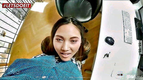May Thai Asian beauty smiling seductively in blue polka dot blouse on webcam