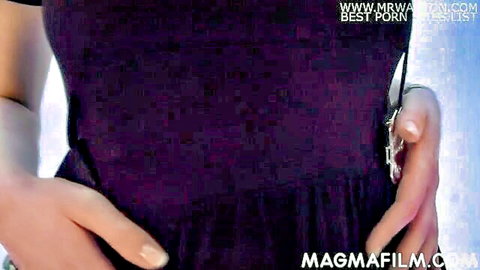 Milka Manson in sexy purple dress, teasing pose from EU lesbian fisting video