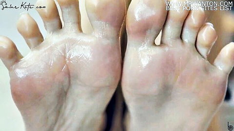 Solar Kate's oiled bare soles close-up, perfect for foot fetish fans