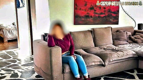 Blurry-faced amateur Latina sitting on couch in tight jeans and sweater teasing curves